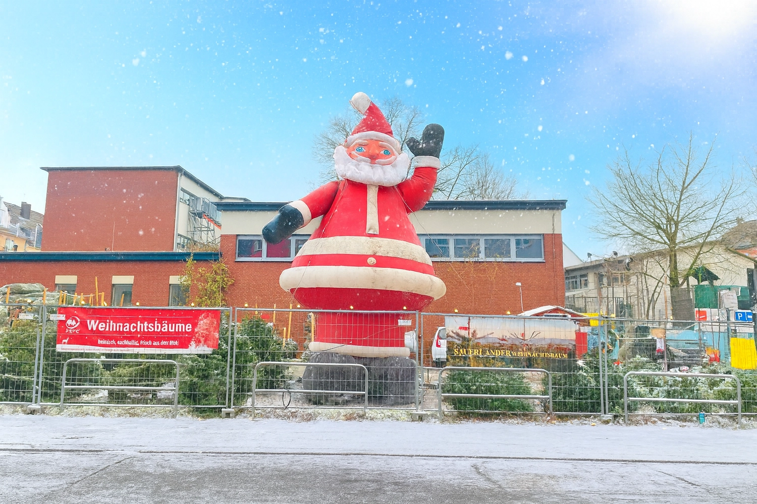 Candidus UG – Häuslicher Krankenpflege – eine große Außenausstellung mit einem riesigen aufblasbaren Weihnachtsmann und einem Stand mit Weihnachtsbäumen.